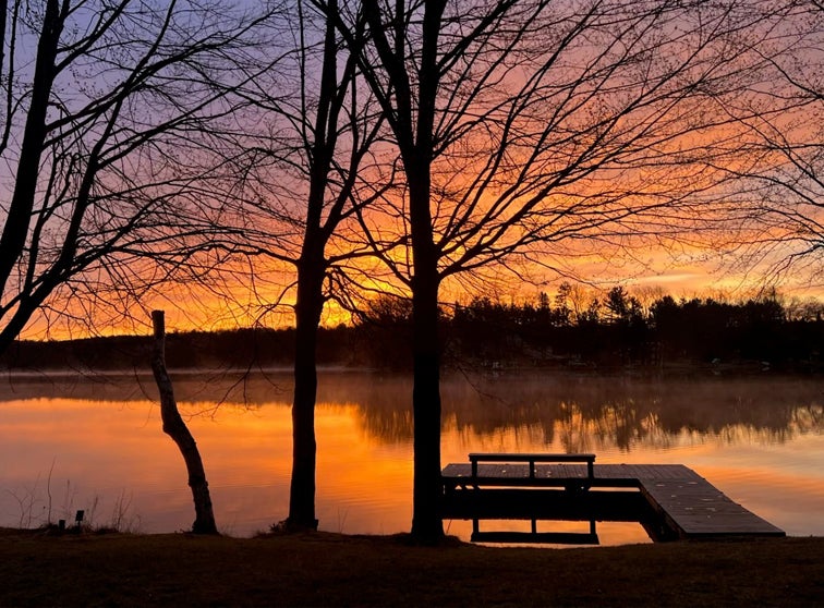 Dock in a lake during a sunset.